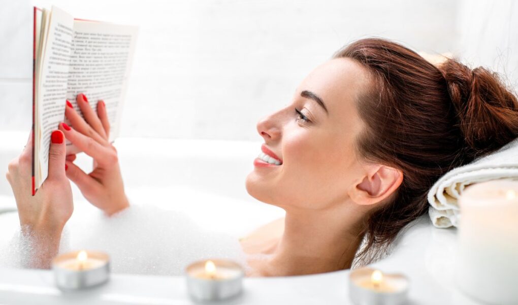 A woman reading a book in a bubble bath