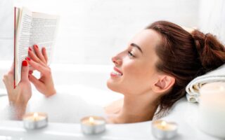 A woman reading a book in a bubble bath