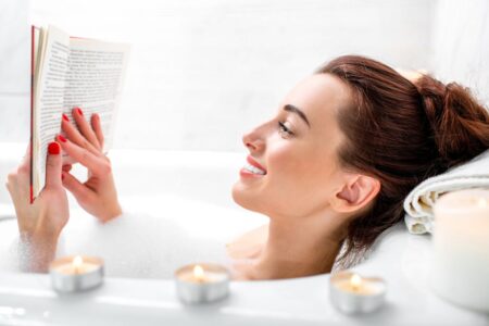 A woman reading a book in a bubble bath